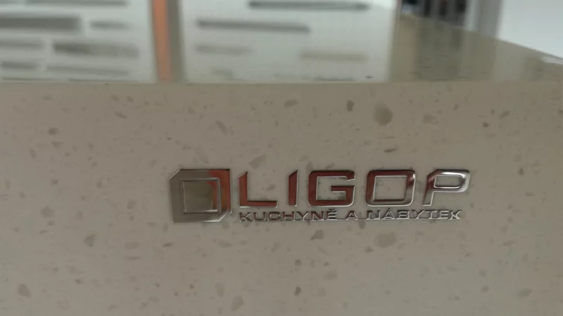 Štítek FINOCHROM® z chromovaného kovu pro výrobce kuchyní a nábytku firmu LIGOP. Jeho linie jsou mimořádně jemné a celý štítek působí téměř jako šperk.